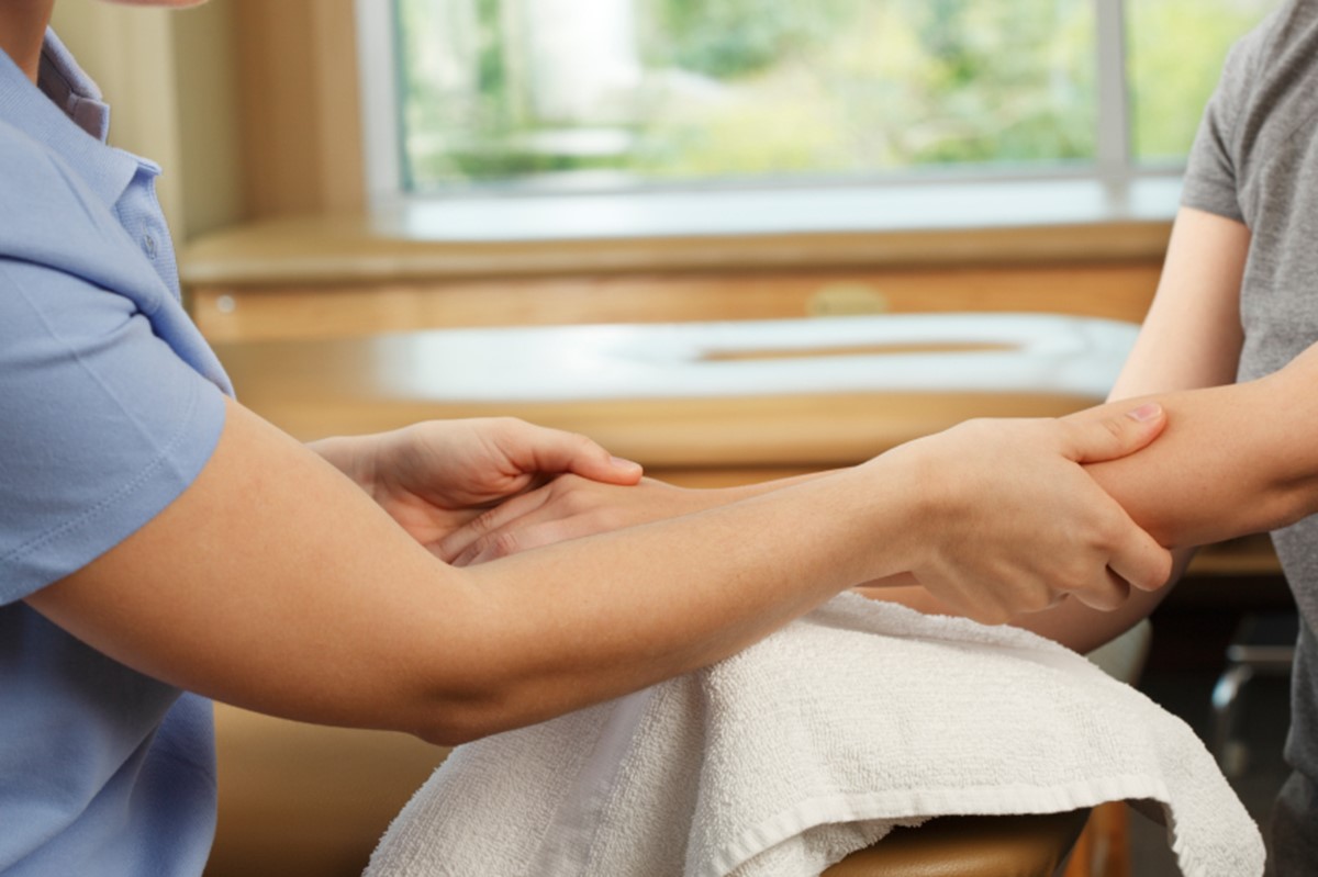 Hand therapist supporting a patient's hand during rehabilitation